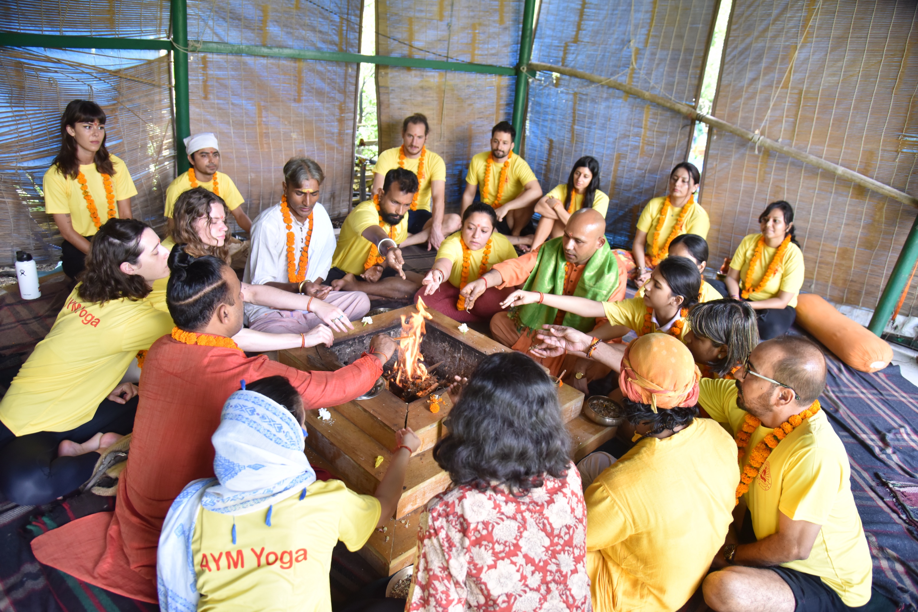 A circle gathered around a fire ceremony during a yoga training
