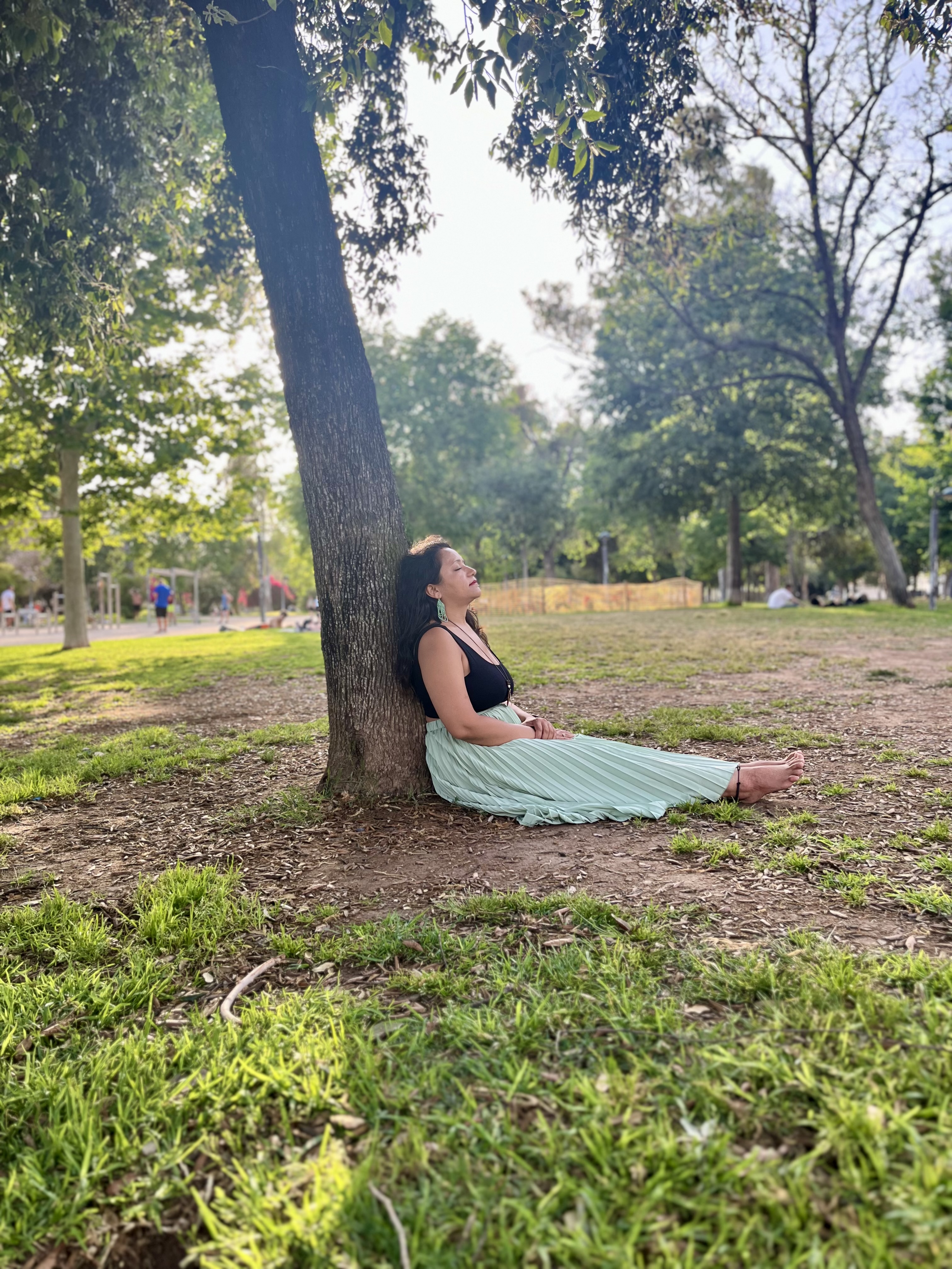 Yashna sitting against a tree with her eyes closed