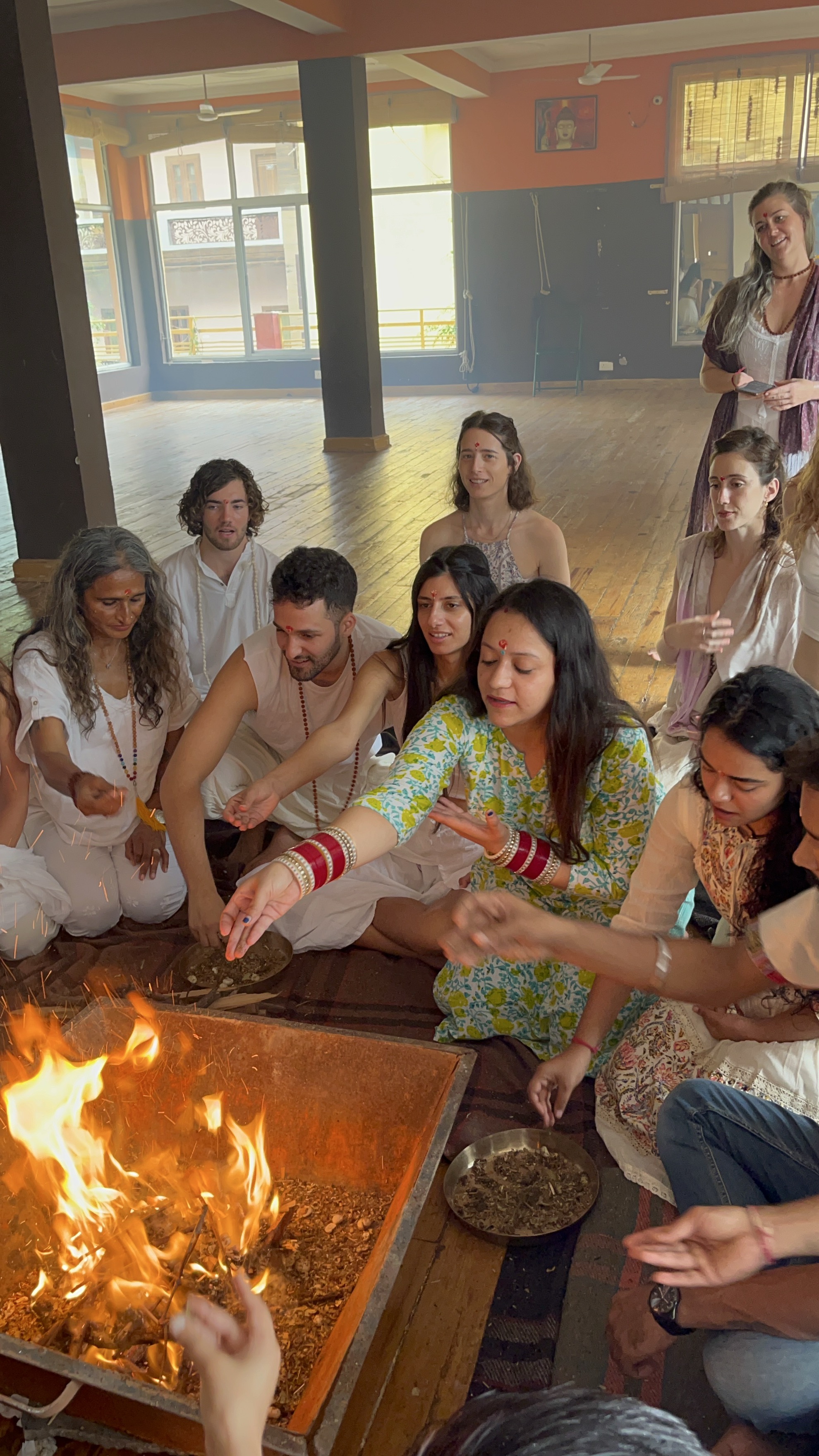 Yashna offering into a fire ceremony indoors with fellow practitioners