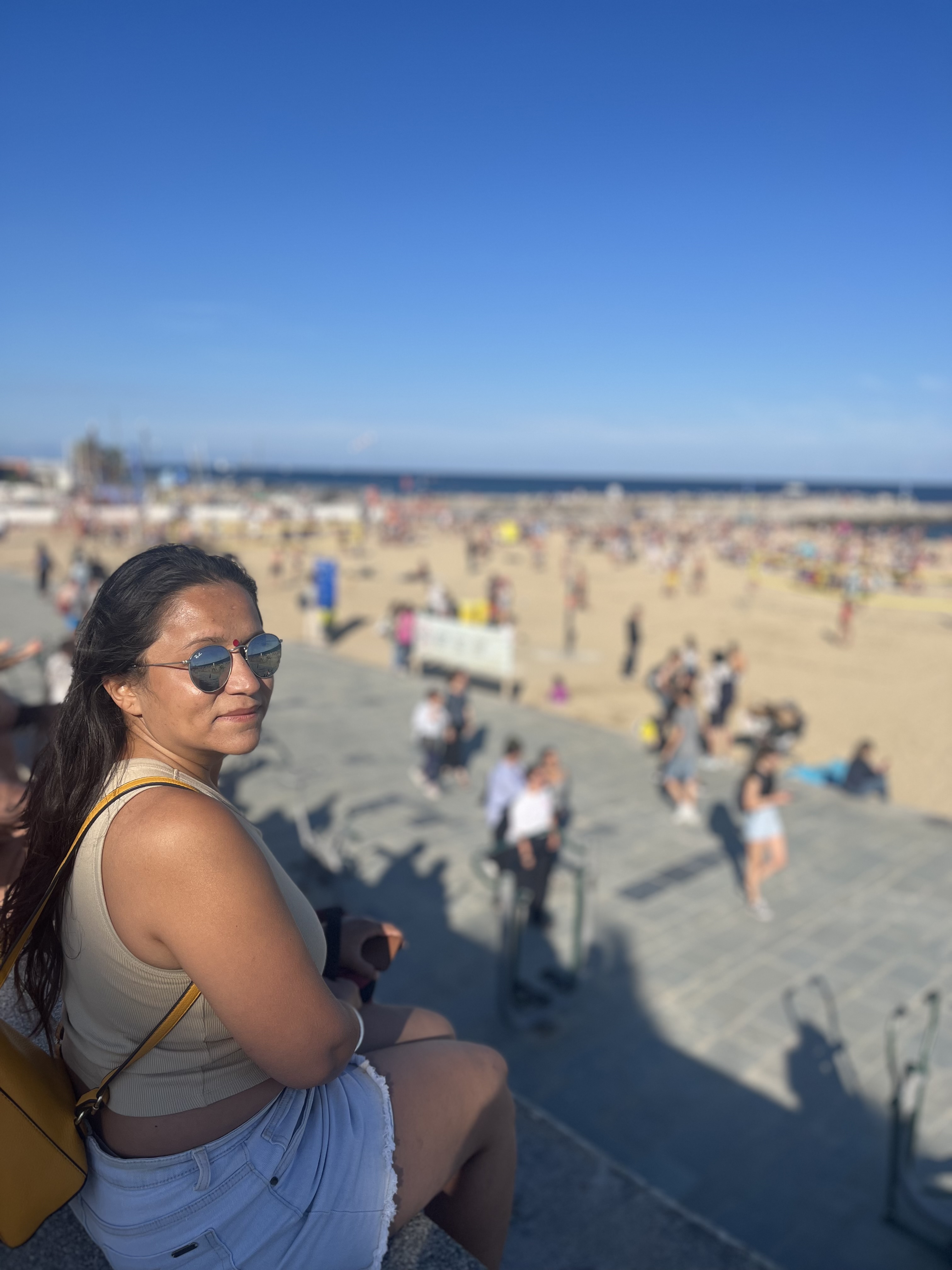 Yashna looking back from a sunny beach promenade