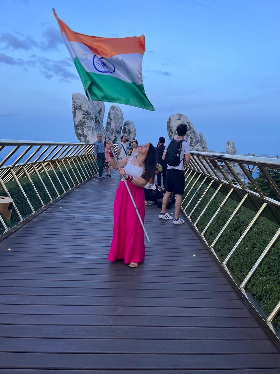 Yashna holding the Indian flag on a high pedestrian bridge